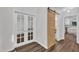 Hallway featuring hardwood floors, a barn door leading to the restroom and french doors at 100 Windvale Ct, Cary, NC 27518