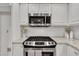 Kitchen area showcasing stainless steel range, granite countertops, and white cabinets with ample storage at 100 Windvale Ct, Cary, NC 27518