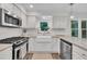 Modern kitchen featuring granite counters, white cabinets, and stainless appliances at 100 Windvale Ct, Cary, NC 27518