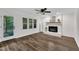 Spacious living room with wood flooring, a white brick fireplace, and a door to the outside at 100 Windvale Ct, Cary, NC 27518