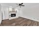 Living room featuring a white painted brick fireplace, wood floors, and a neutral color palette at 100 Windvale Ct, Cary, NC 27518