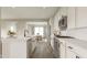 Open kitchen design with white cabinets, stainless steel appliances, and view into the dining area at 1057 Hardin Hill Ln, Knightdale, NC 27545