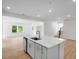 Bright kitchen features an island with stainless steel sink, white cabinets and views to the open living area at 1061 Hardin Hill Ln, Knightdale, NC 27545