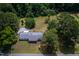 Aerial view of a home with mature trees, a long driveway, and a spacious lot at 1067 Thompson Rd, Four Oaks, NC 27524