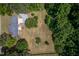 Aerial view of a home with mature trees, a long driveway, and a spacious lot at 1067 Thompson Rd, Four Oaks, NC 27524
