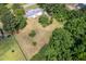Aerial view of a cozy home nestled among mature trees on a spacious lot at 1067 Thompson Rd, Four Oaks, NC 27524