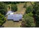 Aerial view of a home with mature trees, a long driveway, and a spacious lot at 1067 Thompson Rd, Four Oaks, NC 27524
