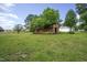 Large backyard with a wooden storage shed surrounded by mature trees at 1067 Thompson Rd, Four Oaks, NC 27524