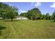 Grassy backyard with mature trees and storage shed on a sunny day at 1067 Thompson Rd, Four Oaks, NC 27524