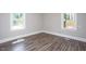 Cozy bedroom with wood-look floors and natural light from two windows at 1067 Thompson Rd, Four Oaks, NC 27524