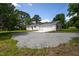 White brick ranch with attached garage, side entry, and gravel driveway at 1067 Thompson Rd, Four Oaks, NC 27524