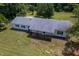 Single story home with white brick, gray roof, black shutters, and covered porch surrounded by lawn at 1067 Thompson Rd, Four Oaks, NC 27524