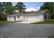 White brick ranch with attached garage, side entry, and gravel driveway at 1067 Thompson Rd, Four Oaks, NC 27524