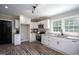 Well-lit kitchen featuring white cabinets, granite countertops, stainless steel appliances, and wood-look floors at 1067 Thompson Rd, Four Oaks, NC 27524