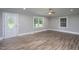 Bright living room featuring a decorative front door, wood-look floors, and large windows at 1067 Thompson Rd, Four Oaks, NC 27524