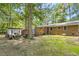 Backyard view of the home with brick exterior, deck, and wooded surroundings at 1139 Princeton Kenly Rd, Kenly, NC 27542