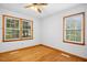 Bedroom featuring hardwood floors, two windows, and a ceiling fan with decorative hardware at 1139 Princeton Kenly Rd, Kenly, NC 27542