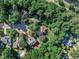 Stunning aerial view of a neighborhood with mature trees and manicured lawns, some houses with private pools at 115 E Seve Ct, Morrisville, NC 27560