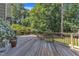Relaxing back deck featuring wood flooring, black railings and a view of the surrounding trees at 115 E Seve Ct, Morrisville, NC 27560