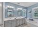 Bright bathroom featuring a double sink vanity, bathtub, and a window with natural light at 115 E Seve Ct, Morrisville, NC 27560