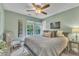 Comfortable bedroom featuring a ceiling fan, large windows, and relaxing decor at 115 E Seve Ct, Morrisville, NC 27560