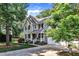 Beautifully landscaped home featuring a lush lawn, mature trees, and a two-car garage at 115 E Seve Ct, Morrisville, NC 27560
