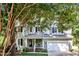 Charming two-story home with a welcoming front porch, lush greenery, and a two-car garage at 115 E Seve Ct, Morrisville, NC 27560