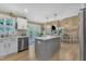 Open-concept kitchen with gray island, stainless steel appliances, white cabinetry, and seamless access to the dining area at 115 E Seve Ct, Morrisville, NC 27560