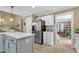 Open-concept kitchen with stainless steel appliances, white cabinets, a kitchen island, and seamless transition to the living area at 115 E Seve Ct, Morrisville, NC 27560
