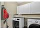 Functional laundry room with white appliances, storage cabinets, and ample counter space at 115 E Seve Ct, Morrisville, NC 27560