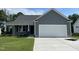 Charming one-story home featuring a two-car garage, and a well-manicured lawn at 140 Oakfield Trace Dr, Four Oaks, NC 27524