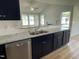 Bright kitchen showcasing granite countertops, navy blue cabinets, and stainless steel appliances at 140 Oakfield Trace Dr, Four Oaks, NC 27524