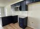 Well-equipped kitchen featuring stainless steel microwave, granite countertops, and navy blue cabinets at 140 Oakfield Trace Dr, Four Oaks, NC 27524
