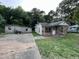 Exterior view of home with stone facade, porch, and detached garage with concrete driveway at 1521 Lewis St, Rocky Mount, NC 27804