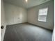 This bedroom has neutral walls, gray carpet, a window and a closet with double doors at 1577 Goldfinch Perch Ln, Knightdale, NC 27545