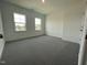 This bedroom has neutral walls, gray carpet, and two windows at 1577 Goldfinch Perch Ln, Knightdale, NC 27545