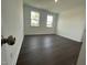 This bedroom has beautiful dark hardwood floors, neutral walls, and two windows at 1577 Goldfinch Perch Ln, Knightdale, NC 27545