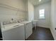Laundry room with washer, dryer, utility sink, and wire shelving at 1577 Goldfinch Perch Ln, Knightdale, NC 27545