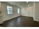 Bright open room featuring hardwood floors, a large window, and a white door with access to other rooms at 1577 Goldfinch Perch Ln, Knightdale, NC 27545