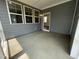 View of a covered patio with gray siding, concrete floor, and large windows at 1577 Goldfinch Perch Ln, Knightdale, NC 27545