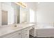 Bright bathroom showcasing a large vanity, jacuzzi tub, and a window for natural light at 1613 Patterson Grove Rd, Apex, NC 27502