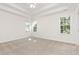 Spacious bedroom featuring tray ceiling, neutral carpet, and lots of natural light from three windows at 1613 Patterson Grove Rd, Apex, NC 27502