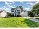 Beautiful two-story home with lush green lawn, attached garage, and classic architectural details on a sunny day at 1613 Patterson Grove Rd, Apex, NC 27502