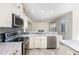 Modern kitchen featuring stainless steel appliances, gray backsplash, and marble countertops at 1613 Patterson Grove Rd, Apex, NC 27502