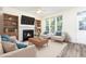 Comfortable living room with a fireplace, built-in bookshelves, and abundant natural light from large windows at 1613 Patterson Grove Rd, Apex, NC 27502