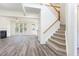 Bright living room showcasing wood floors, a fireplace, and an open staircase leading to the second floor at 1613 Patterson Grove Rd, Apex, NC 27502