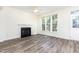 Inviting living room featuring a fireplace, large windows, and modern flooring for a comfortable living space at 1613 Patterson Grove Rd, Apex, NC 27502