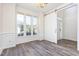 Elegant living room with wainscoting, large windows, modern sliding barn door and stylish, wood-like flooring at 1613 Patterson Grove Rd, Apex, NC 27502