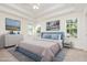 Calm main bedroom featuring a tray ceiling, a plush bed, and ample natural light from three windows at 1613 Patterson Grove Rd, Apex, NC 27502