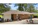 Exterior photo of the backyard showing the brick home with a covered patio and outdoor seating area at 1832 Blandwood Dr, Rocky Mount, NC 27801